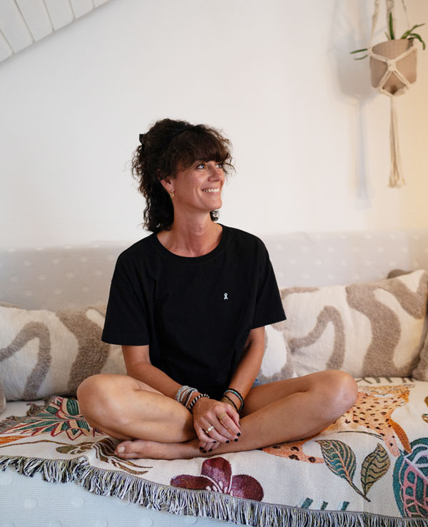 Jennifer Stracke Portrait lächelnd im Schneidersitz auf dem Sofa